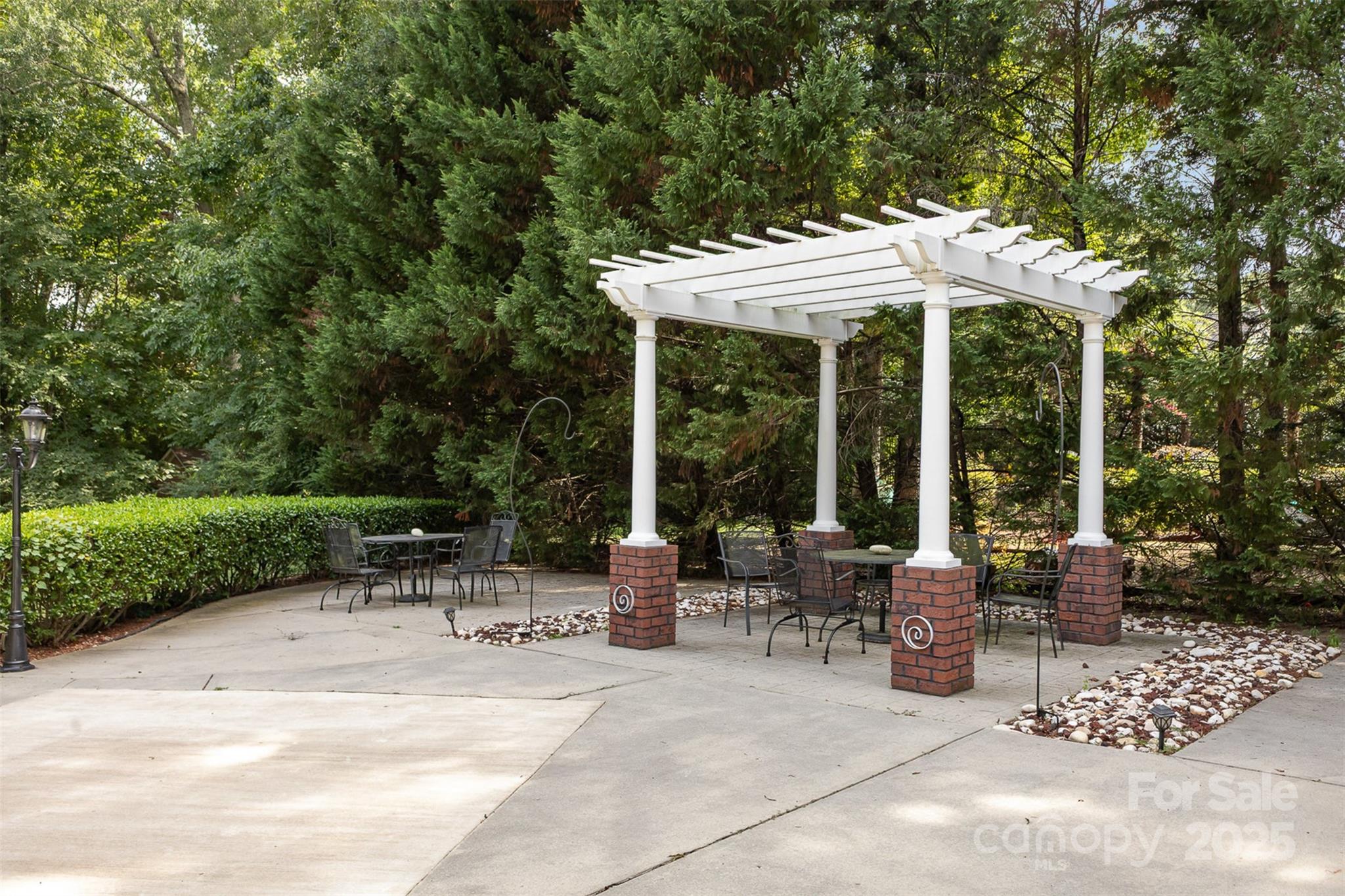 5619 Weddington Road Concord, NC 28027 - Photo 39 of 48 a view of a patio with a dining table and chairs under an umbrella with a large tree