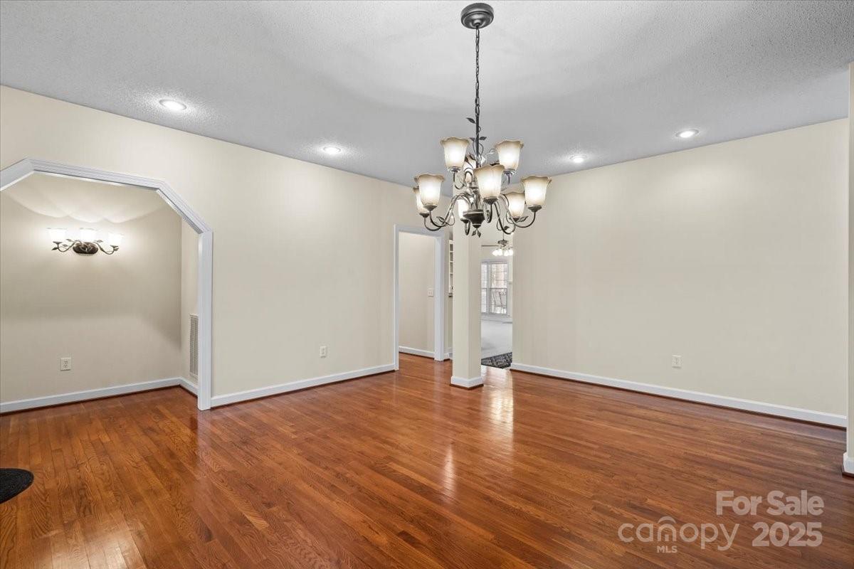 5619 Weddington Road Concord, NC 28027 - Photo 8 of 48 a view of a room with a chandelier and wooden floor
