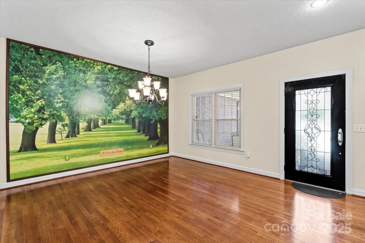 5619 Weddington Road Concord, NC 28027 - Photo 9 of 48 a view of a room that has a floor to ceiling window and wooden floor