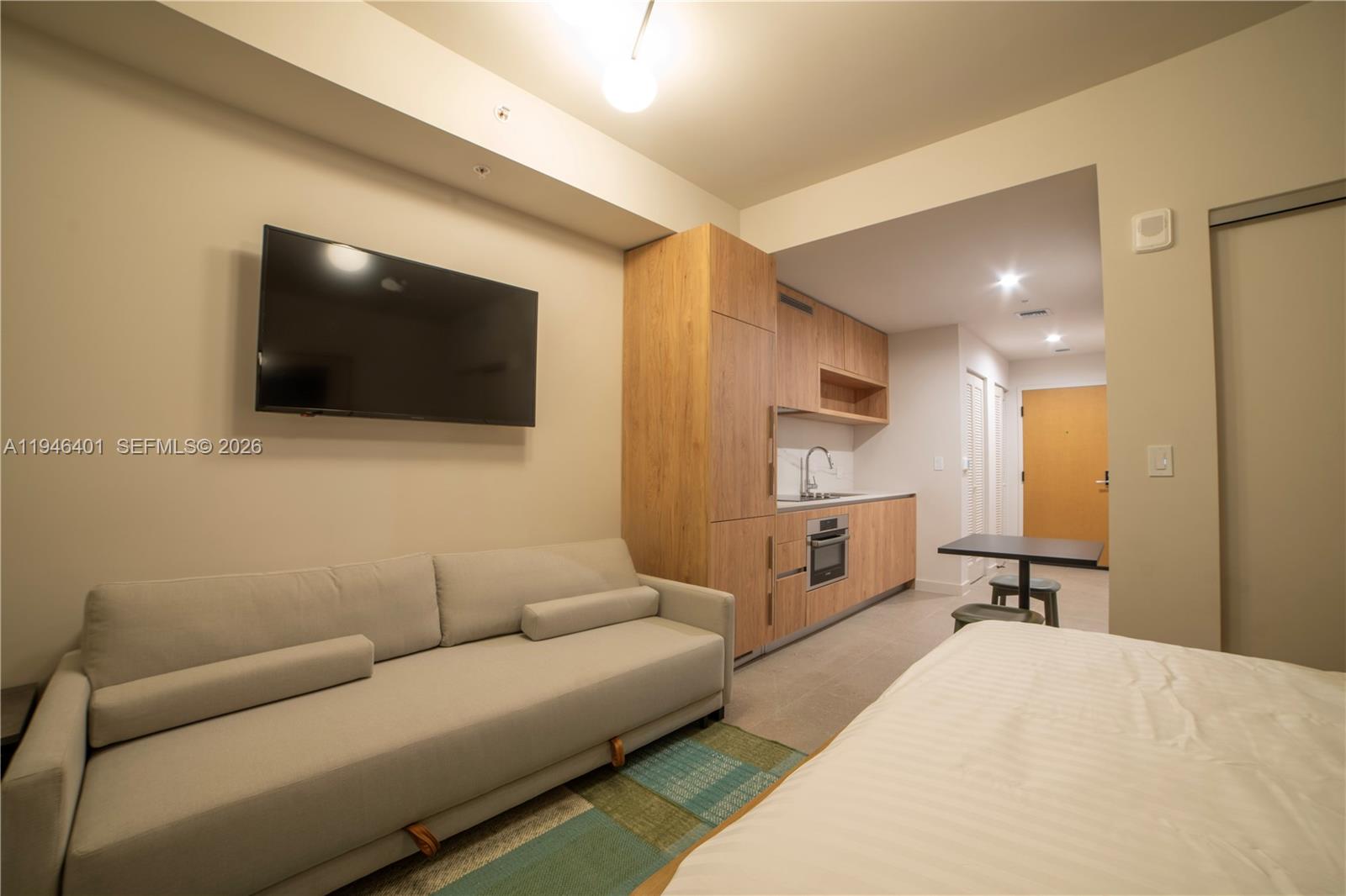 11 Northeast 6th Street, Unit 1908 Miami, FL 33132 - Photo 2 of 38 a living room with furniture and a flat screen tv