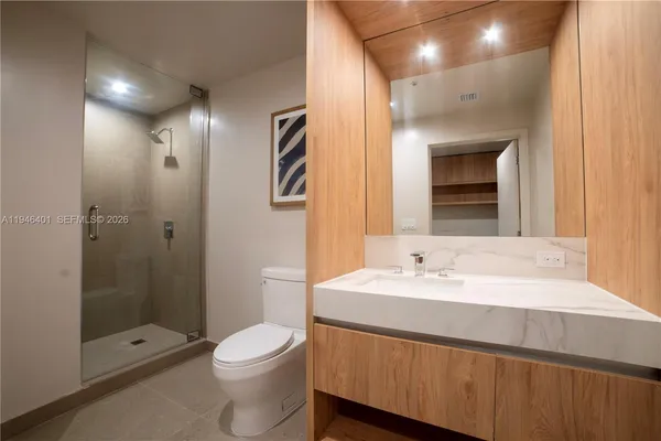 a bathroom with a sink a toilet and shower