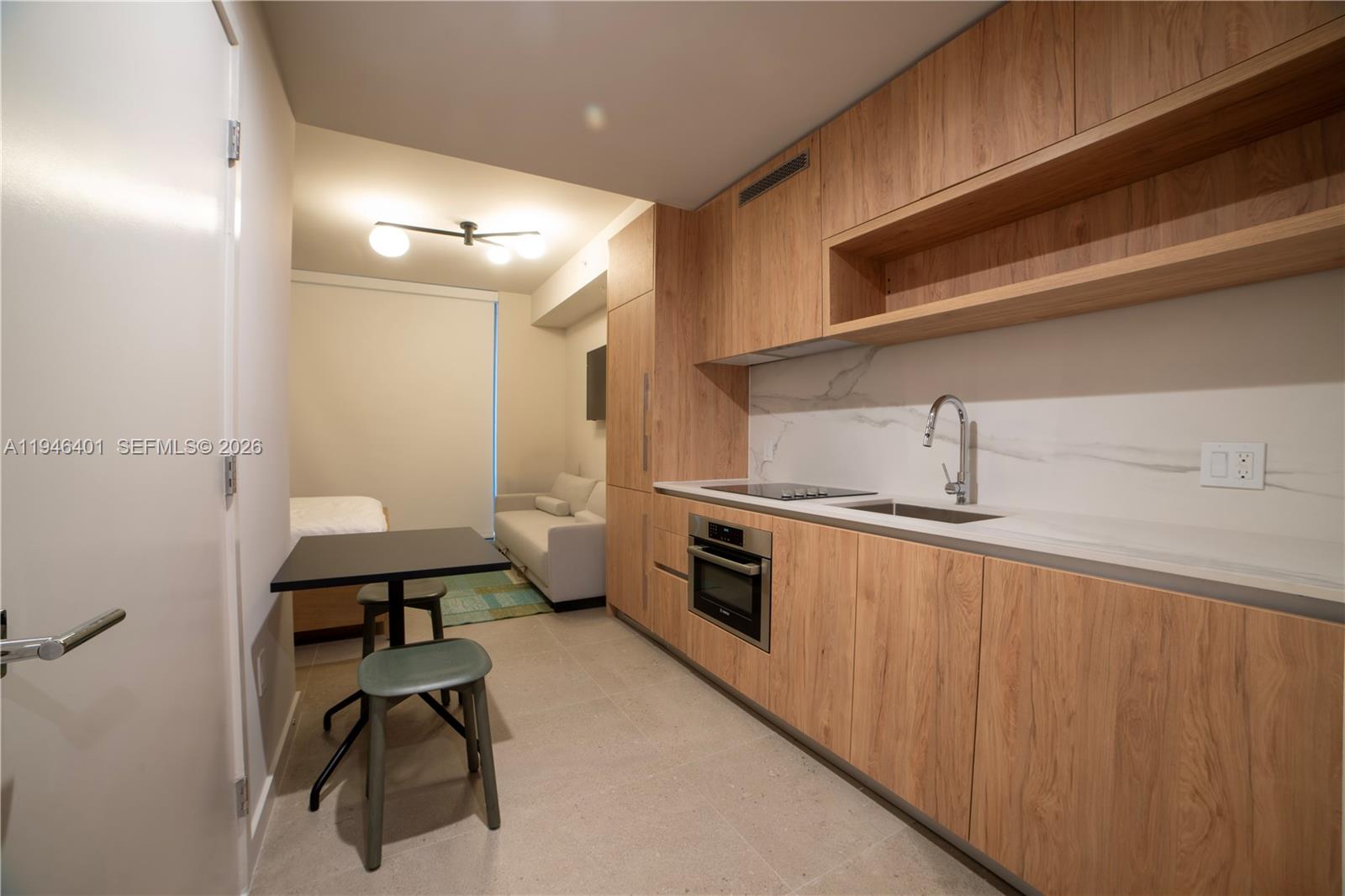 11 Northeast 6th Street, Unit 1908 Miami, FL 33132 - Photo 4 of 38 a kitchen with sink cabinets and stove top oven