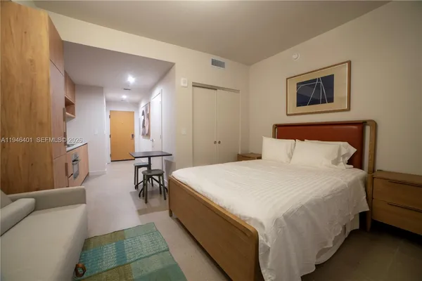a spacious bedroom with a bed and a table in it