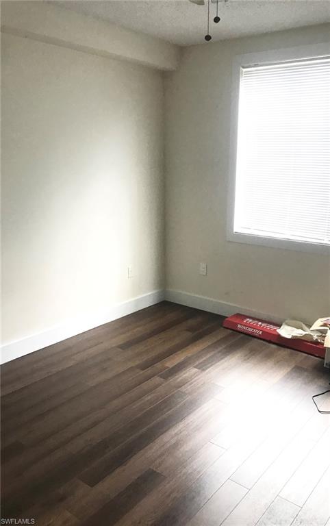 1115 Reserve Court, Unit 2 Naples, FL 34105 - Photo 1 of 2 Interior room featuring wood-finish flooring, white baseboards, and a single window with horizontal blinds