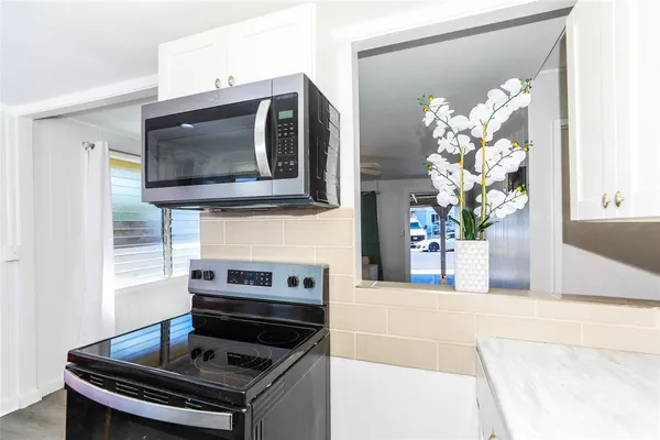 a kitchen with stainless steel appliances granite countertop a stove and a microwave