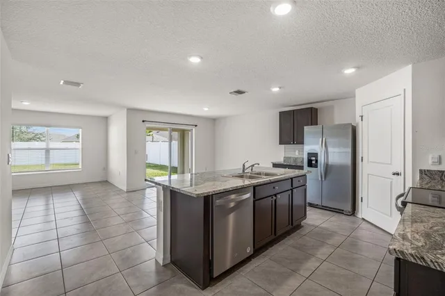 a kitchen with stainless steel appliances granite countertop a stove top oven a sink and a granite counter tops