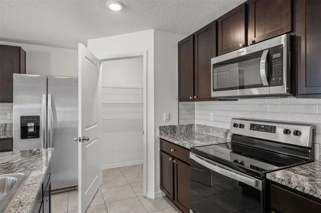 a large white kitchen with a stove a sink and a refrigerator