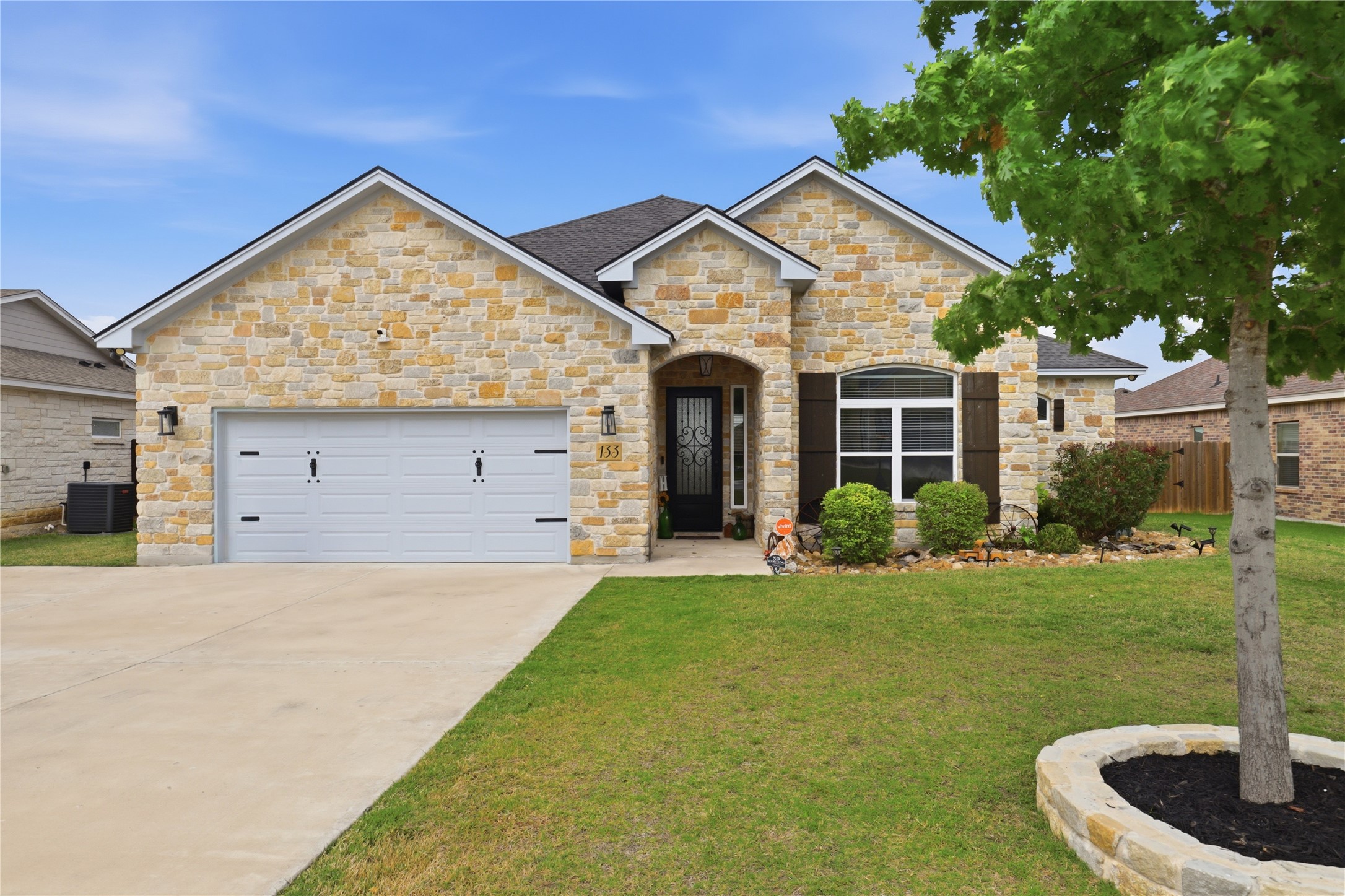 133 Greg Lane Jarrell, TX 76537 - Photo 3 of 24 Stone veneer facade with an arched entryway and dark wood window shutters
