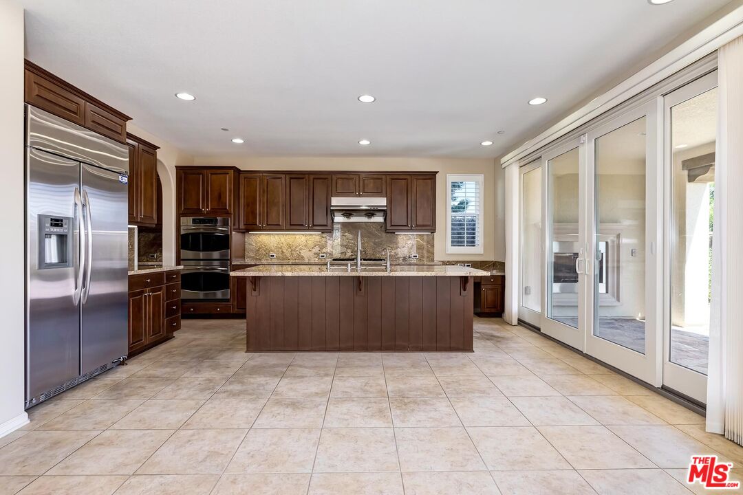 11656 North Ricasoli Way Porter Ranch, CA 91326 - Photo 12 of 51 a kitchen with stainless steel appliances granite countertop a refrigerator and a sink