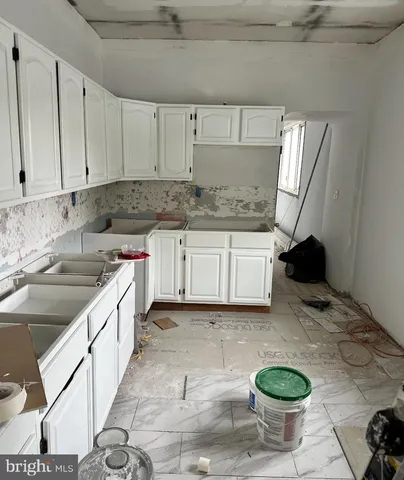 a kitchen with a sink a stove and white cabinets