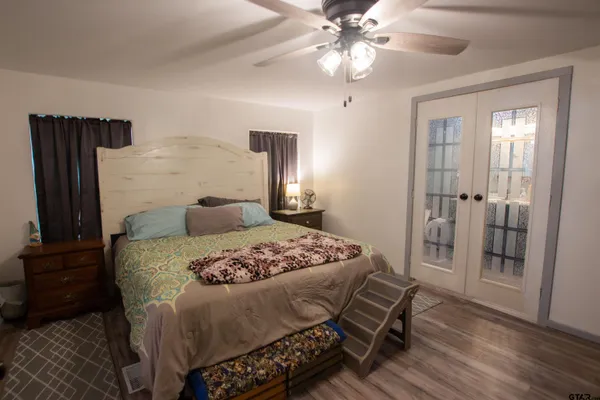a bedroom with a bed and wooden floor
