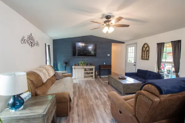 a living room with furniture a dining table and a flat screen tv