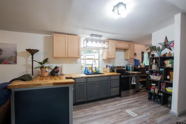 a kitchen that has a sink cabinets and wooden floor