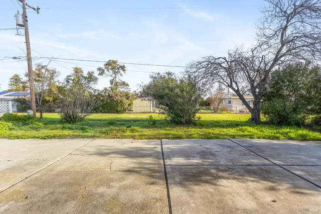 a view of a house with a big yard and potted plants