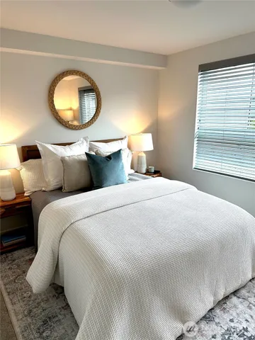 a bedroom with a bed and a mirror on dresser