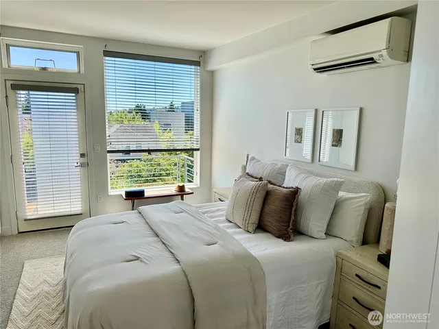 a bedroom with a bed and a large window