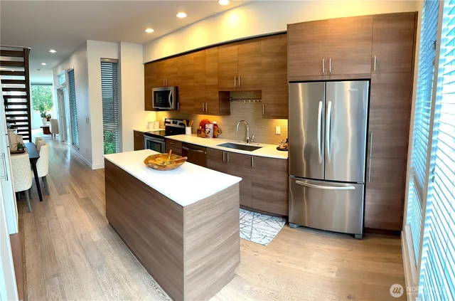 a kitchen with stainless steel appliances a refrigerator a sink dishwasher and a stove top oven