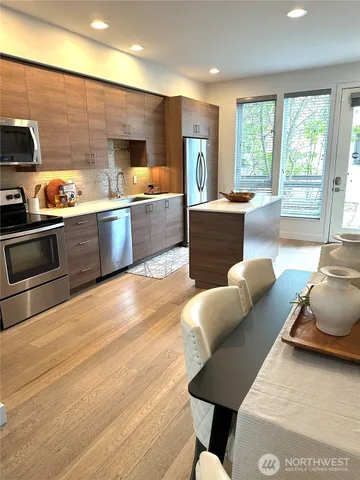 a kitchen with stainless steel appliances living room dining table and chairs