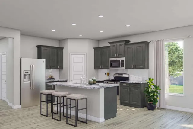 a kitchen with stainless steel appliances granite countertop a refrigerator a stove a sink a microwave a dining table and chairs with wooden floor