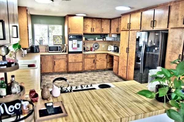 a kitchen with stainless steel appliances kitchen island granite countertop a refrigerator and a stove top oven