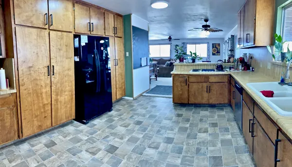a kitchen with stainless steel appliances granite countertop a refrigerator a stove and a sink with cabinets