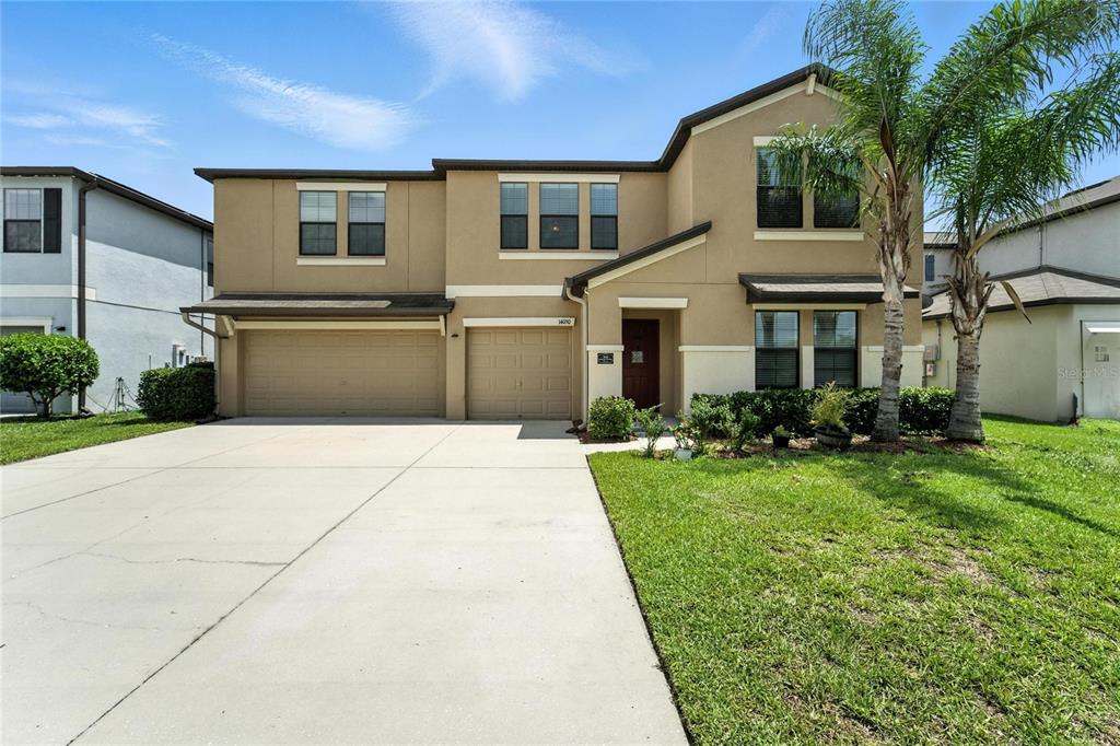 a front view of a house with a yard and garage