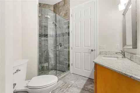 a bathroom with a double vanity sink toilet and shower