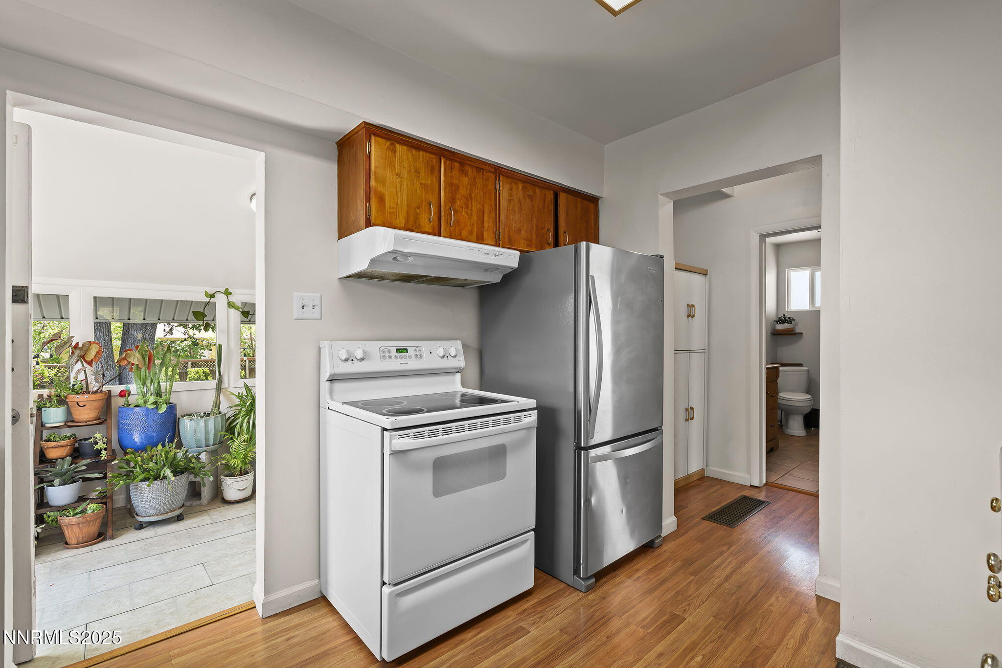 704 Roberts Street Reno, NV 89502 - Photo 12 of 52 a kitchen with a stove a refrigerator and a wooden floor