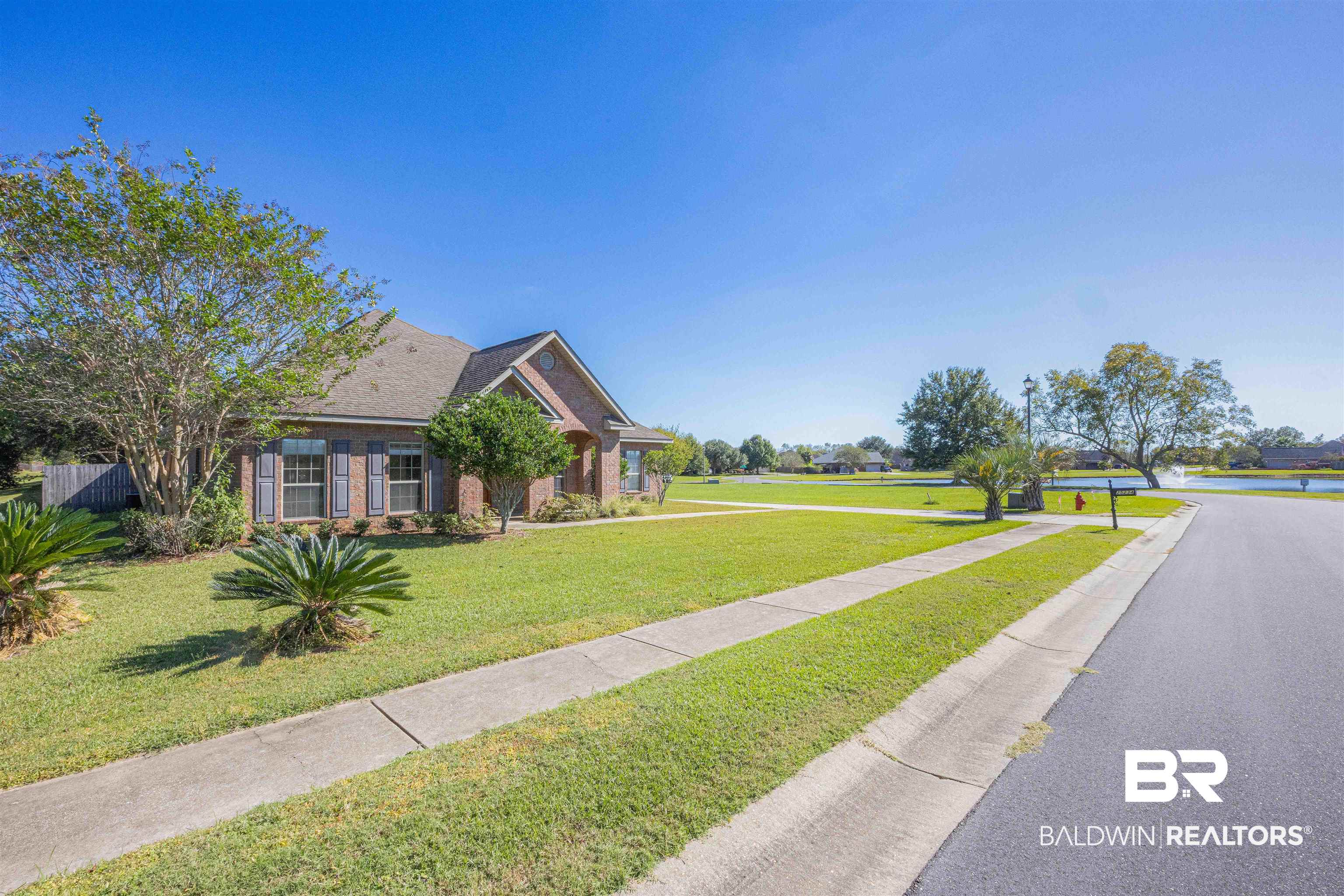 25234 Fairfax Road Daphne, AL 36526 - Photo 6 of 45 View of front facade with a front lawn, brick siding, and roof with shingles