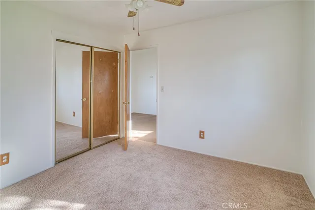 an empty room with chandelier fan