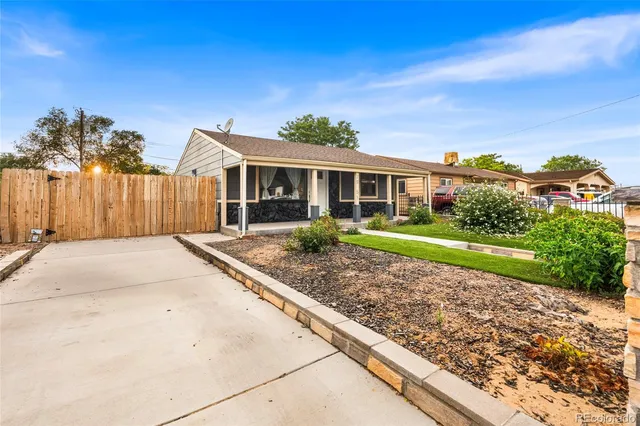 a front view of a house with a yard and potted plants