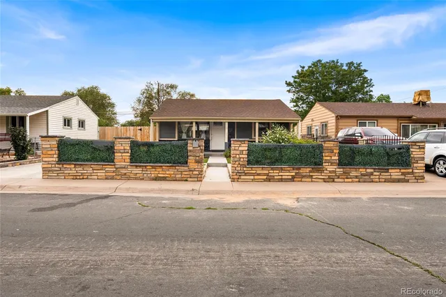 a front view of a house with a yard and potted plants