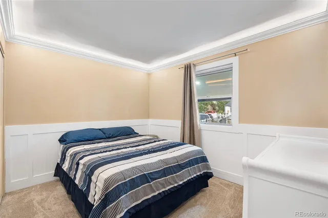 a bedroom with a bed and a window with rug