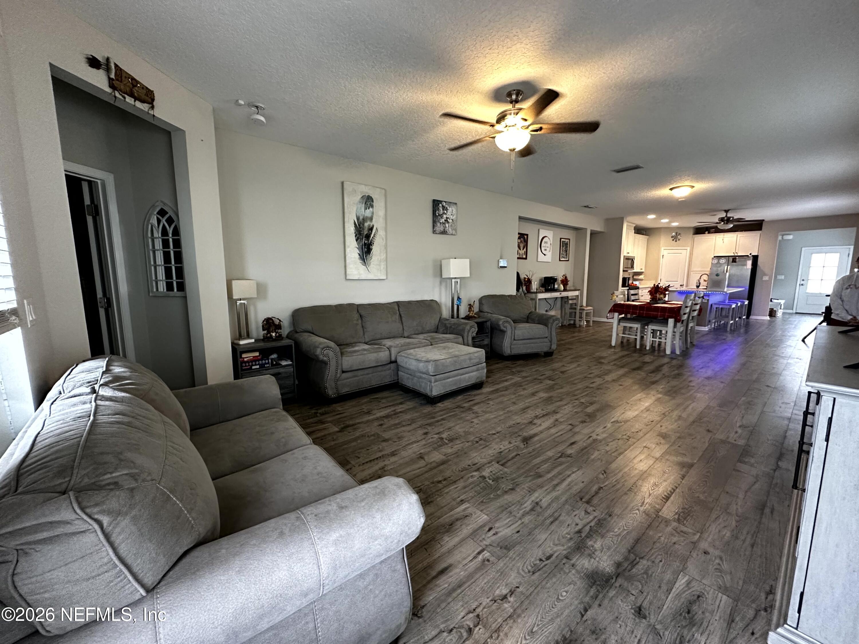 177 Clarys Run St. Augustine, FL 32092 - Photo 15 of 16 a living room with furniture and a chandelier