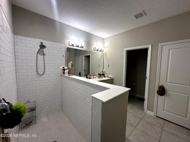 a bathroom with a sink a toilet a mirror and shower