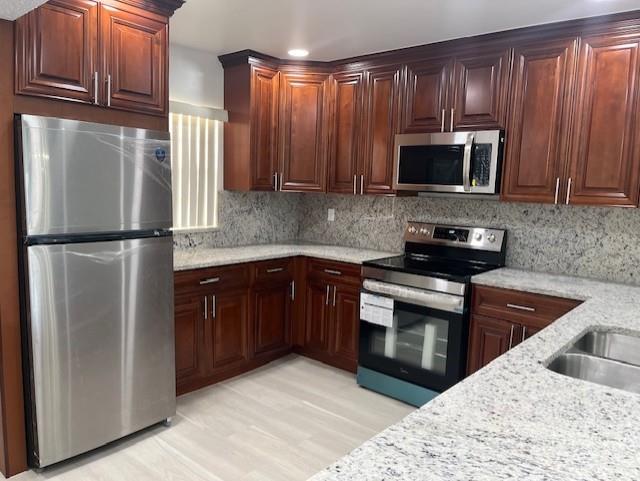 5100 Southwest 90th Avenue, Unit 410 Cooper City, FL 33328 - Photo 5 of 15 a kitchen with granite countertop a refrigerator stove and microwave