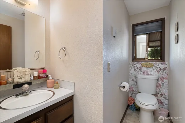 a bathroom with a sink vanity mirror and toilet