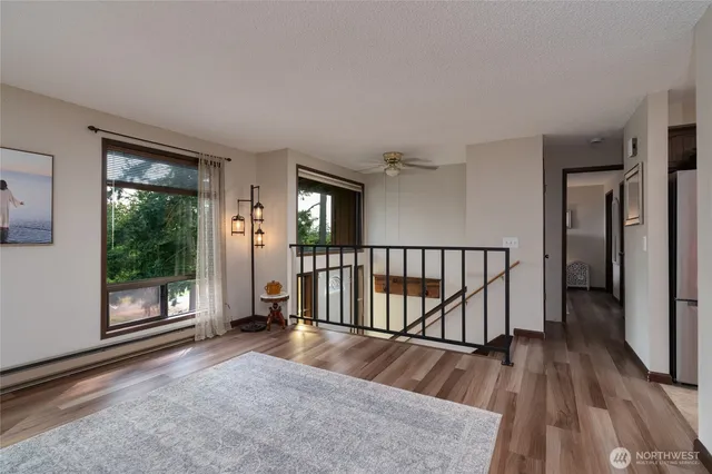 a view of a hallway with wooden floor and windows