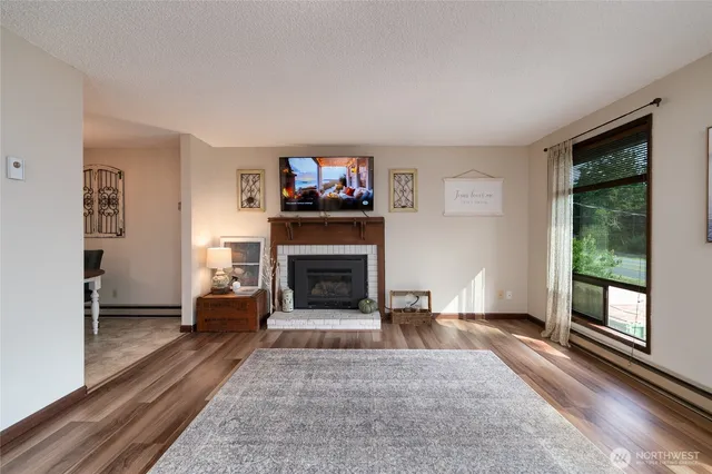 a living room with furniture a flat screen tv and a fireplace