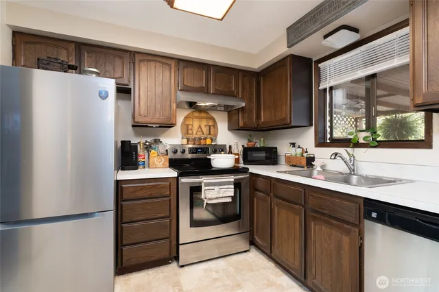 a kitchen with a sink a refrigerator and a stove