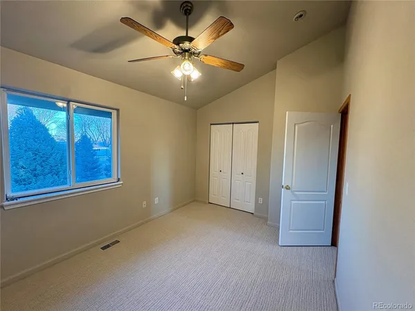 en empty room with windows and fan