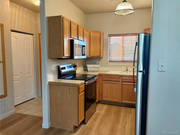 a kitchen with stainless steel appliances granite countertop a stove a sink and a refrigerator
