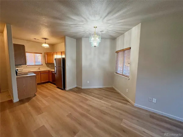 a view of a kitchen with a sink a refrigerator and windows