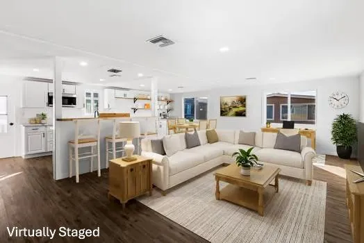 a living room with furniture and a view of kitchen