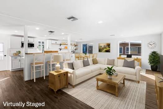a living room with furniture and a view of kitchen