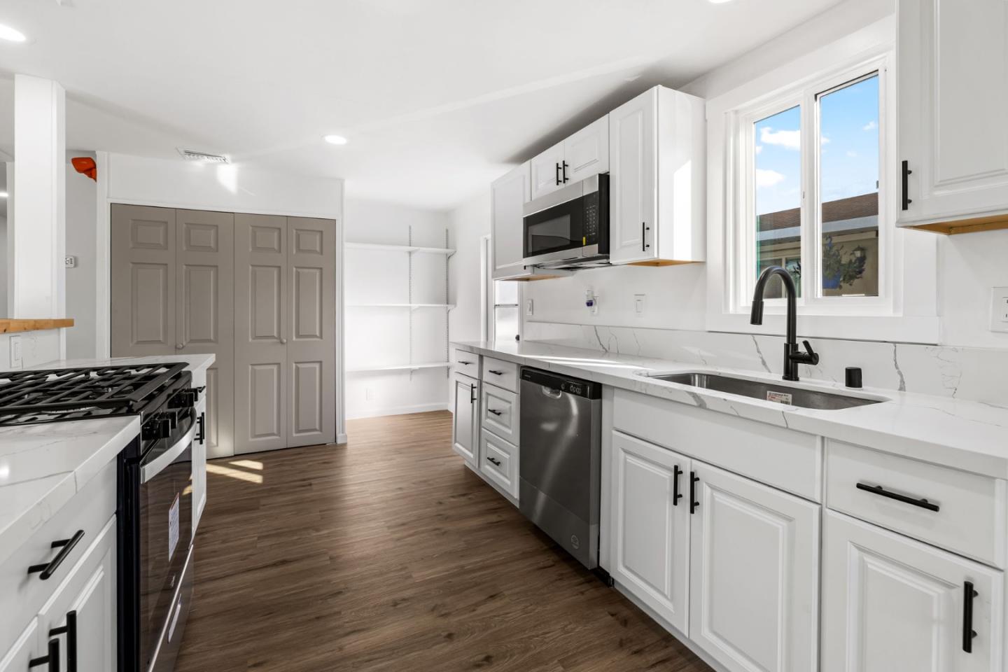 20 Russell Road, Unit 86 Salinas, CA 93906 - Photo 14 of 43 a kitchen with stainless steel appliances a sink dishwasher stove and oven with wooden floor