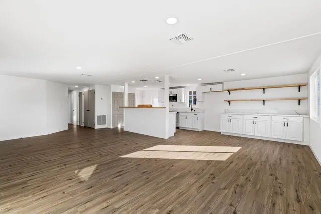 a kitchen with appliances cabinets and a wooden floor