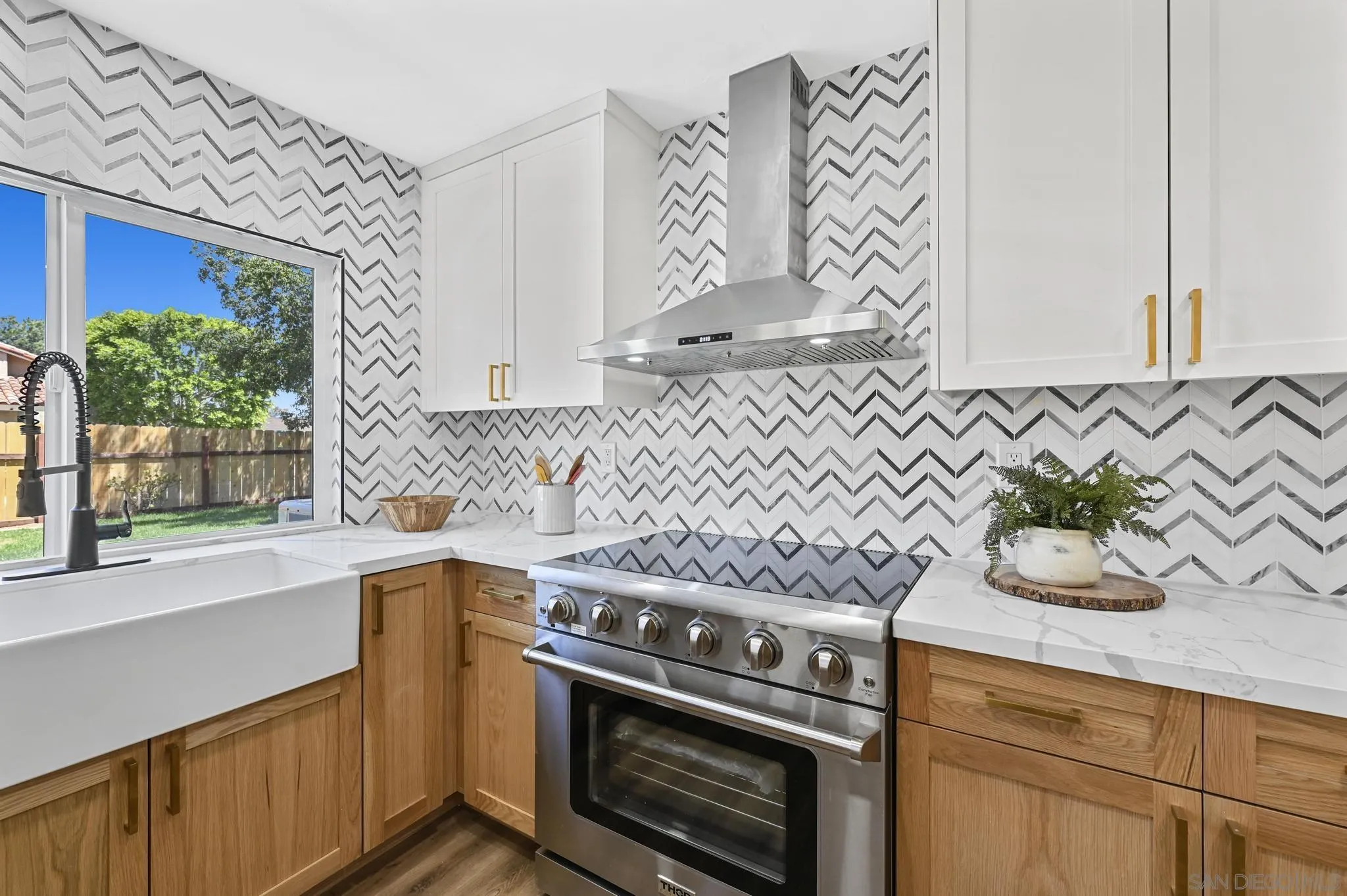 14463 Janal Way San Diego, CA 92129 - Photo 16 of 44 a kitchen with granite countertop white cabinets and a stove