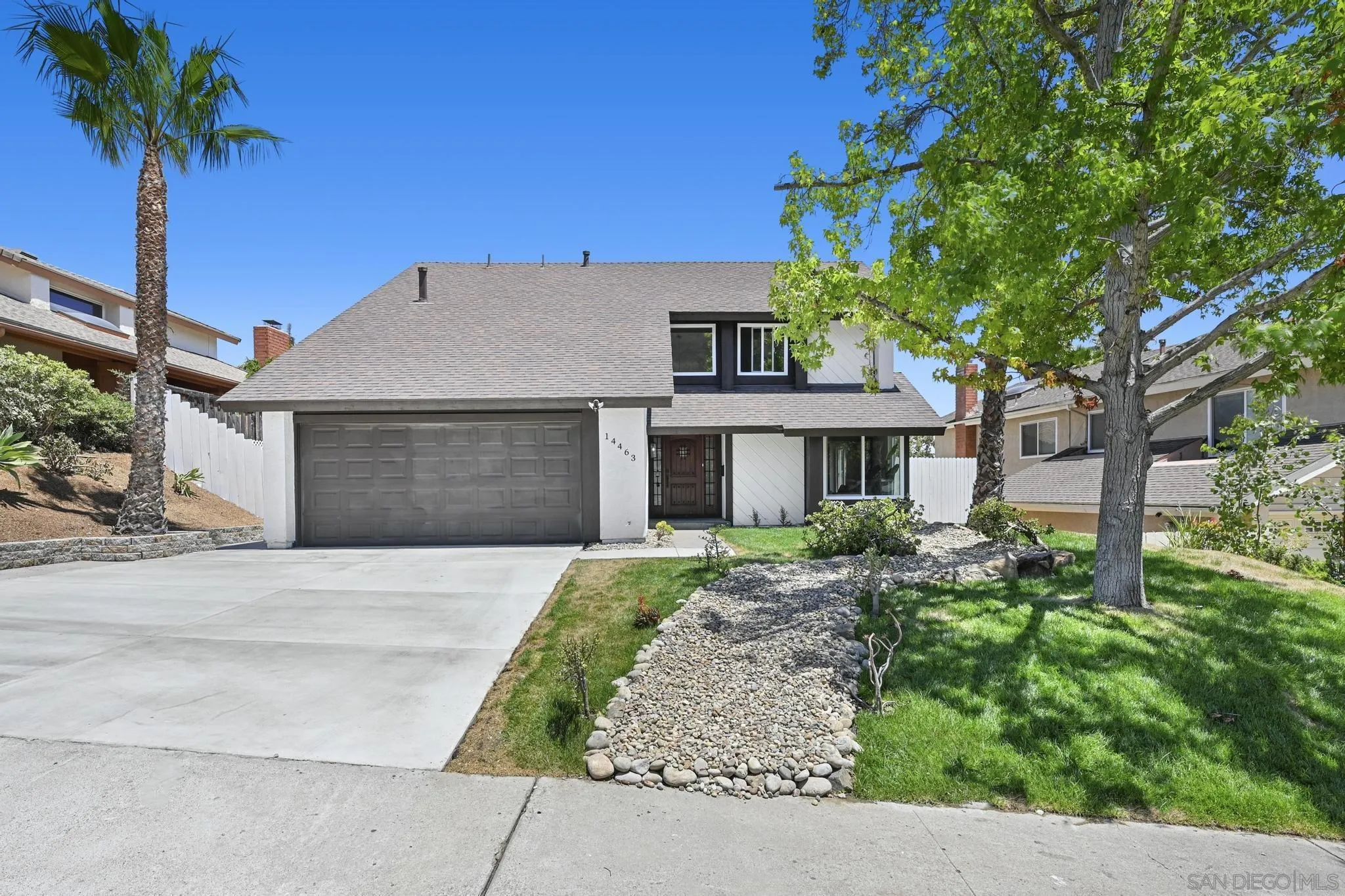14463 Janal Way San Diego, CA 92129 - Photo 2 of 44 a front view of a house with a garden and trees