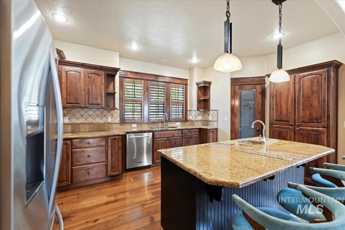 2543 West Divide Creek Street Meridian, ID 83646 - Photo 14 of 49 Kitchen with stainless steel appliances, open shelves, decorative light fixtures, light stone countertops, and recessed lighting